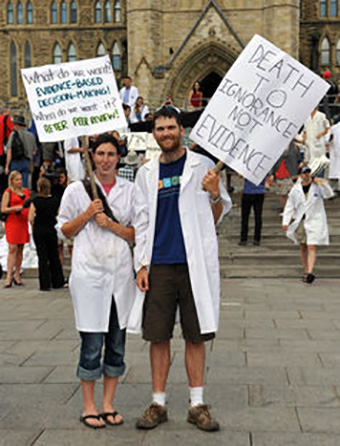Does wearing a lab coat and holding a witty jargon-laden sign send the right message? Shutterstock